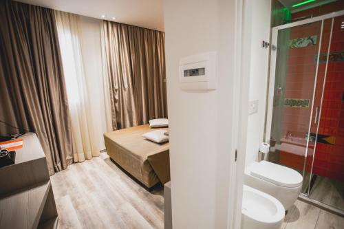 a small bathroom with a bed and a toilet at Hotel Fiera Wellness & Spa in Bologna