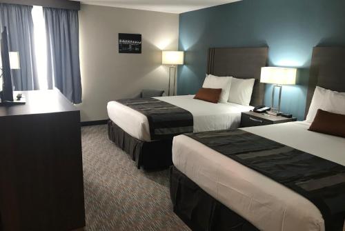 a hotel room with two beds and a desk at Nobile Hotel Parkway at Celebration Orlando Very Close to Disney Theme Parks in Orlando