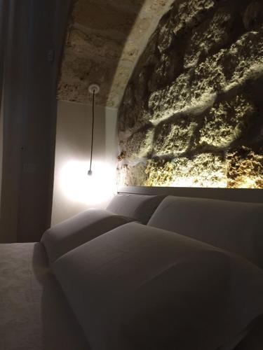 a bed in a room with a stone wall at Suite Cavour B&B in Galatina