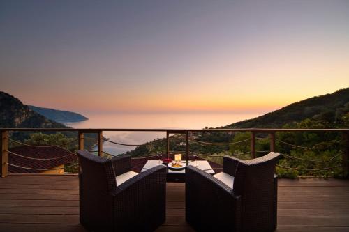 a balcony with two chairs and a table with a view at Lissiya Hotel in Faralya