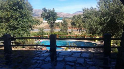 - une vue sur la piscine à travers une clôture dans l'établissement La Simona Casa Rural, à Perales del Puerto