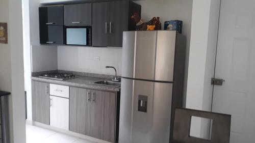uma cozinha com um frigorífico e um lavatório em APARTAMENTO AVENIDA CONDINA Primer Piso em Pereira