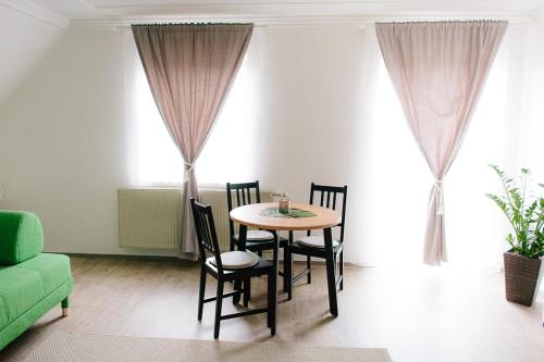 a dining room table with chairs and a green couch at Steira-Studios in Ehrenhausen