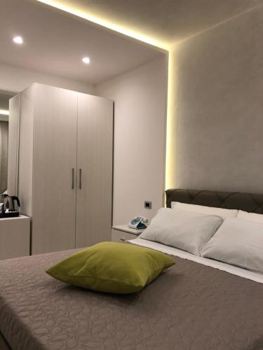 a bedroom with a bed with a green pillow on it at B&B Rossini Luxury in Rende