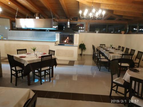una sala da pranzo con tavoli, sedie e camino di Resort La Selva a San Severino Lucano