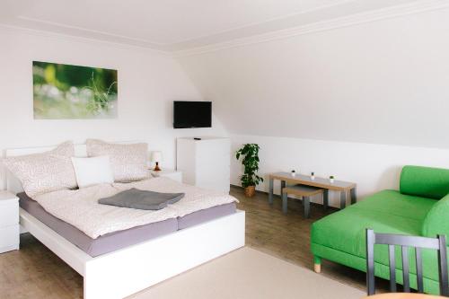 una camera con letto e divano verde di Steira-Studios a Ehrenhausen