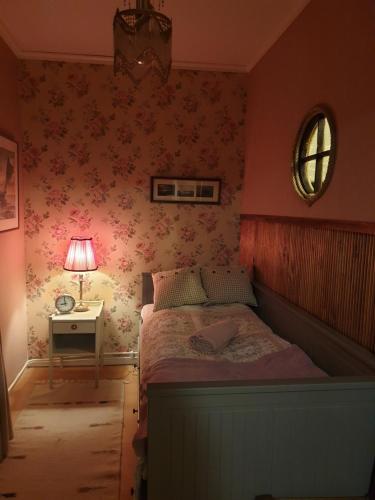 1 dormitorio con 1 cama y 1 mesa con lámpara en Katariinan Kamari en Raahe