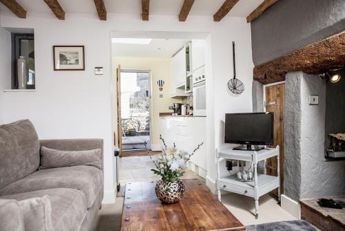 a living room with a couch and a tv at The Nook, Gretton (Cotswolds) in Gretton