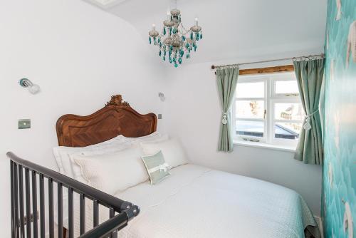 Schlafzimmer mit einem Bett und einem Kronleuchter in der Unterkunft The Nook, Gretton (Cotswolds) in Gretton
