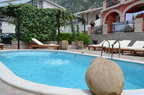 a large swimming pool with a large rock in front of a building at Apartments Bogdanovic in Kotor