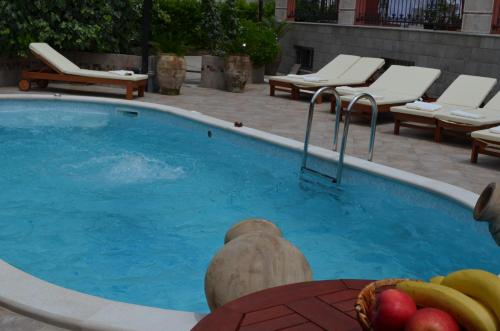een groot zwembad met een bos fruit erin bij Apartments Bogdanovic in Kotor
