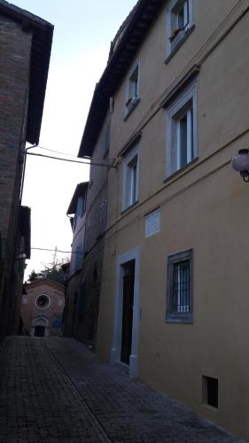 烏比諾的住宿－Via Barocci 34，一座建筑在鹅卵石街道上,毗邻一座建筑