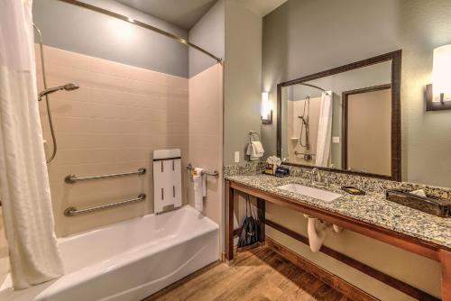 a bathroom with a tub and a sink and a mirror at Best Western Plus Overland Inn in Fort Morgan