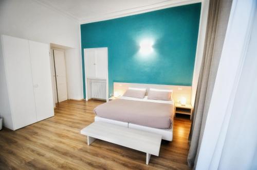 a bedroom with a white bed and a blue wall at Torino 1854 Affittacamere in Turin