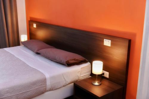 a bedroom with a bed with an orange wall at Torino 1854 Affittacamere in Turin