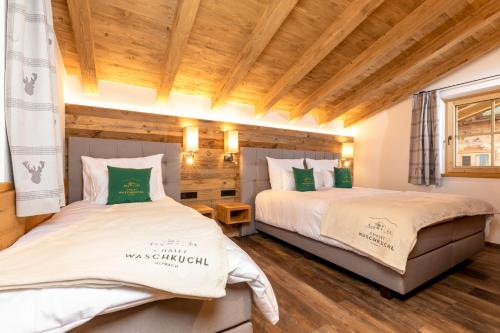 dwa łóżka w pokoju z drewnianym sufitem w obiekcie Chalet Waschkuchl w Alpbach