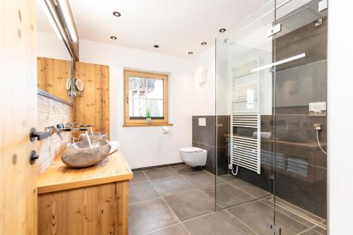 łazienka z umywalką i przeszkloną kabiną prysznicową w obiekcie Chalet Waschkuchl w Alpbach