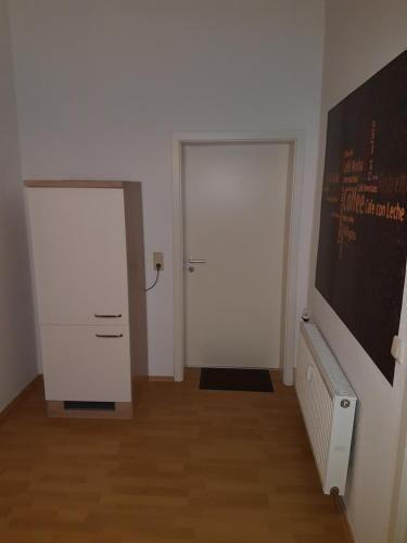 an empty room with two white doors and wooden floors at Altstadtflair in Wernigerode