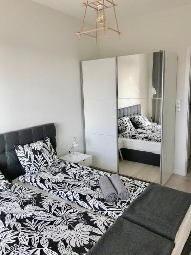 a bedroom with a large bed and a mirror at Apartament Antoniny in Leszno