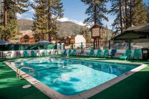 basen w ośrodku z niebieskimi krzesłami i drzewami w obiekcie Big Pines Mountain House w mieście South Lake Tahoe