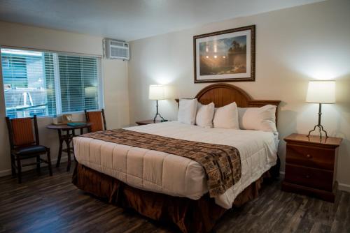 a hotel room with a large bed and a table at Big Pines Mountain House in South Lake Tahoe
