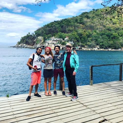 four people standing on a dock near the water at Casa Kraken Hostel in Puerto Vallarta