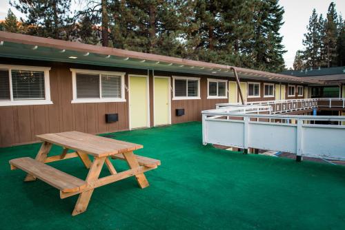 a picnic table sitting on a green floor next to a building at Tea Garden Lodge in South Lake Tahoe