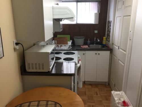 a kitchen with a stove and a microwave on a counter at Private Room near Airport in Mississauga