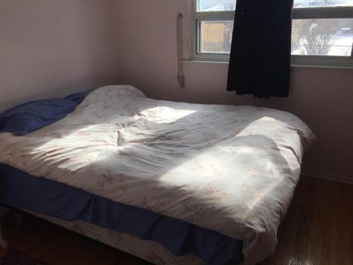 a small bed in a room with a window at Private Room near Airport in Mississauga