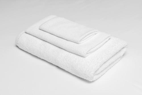 una pila de toallas blancas en un fondo blanco en Knights Inn St. George, en Saint George
