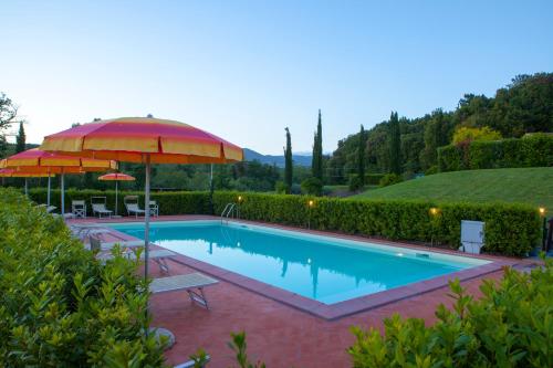 a swimming pool with an umbrella and a table and chairs at Casa Vacanze "Casale al Pino" in Riparbella