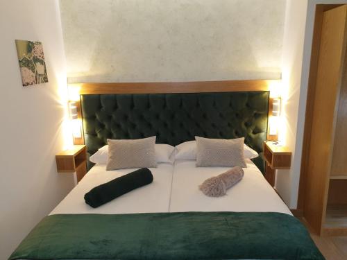 a bedroom with a large bed with two pillows on it at Casa da Balconada in Santiago de Compostela