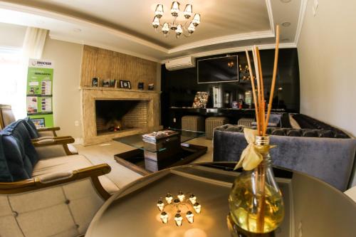 a living room with a table and a fireplace at Hotel Gramado Interlaken in Gramado