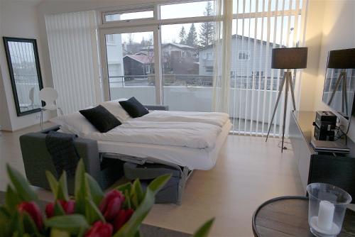 a bedroom with a bed and a large window at Om Apartments in Reykjavík
