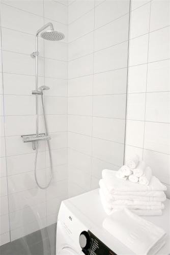 a white bathroom with a shower and towels at Om Apartments in Reykjavík