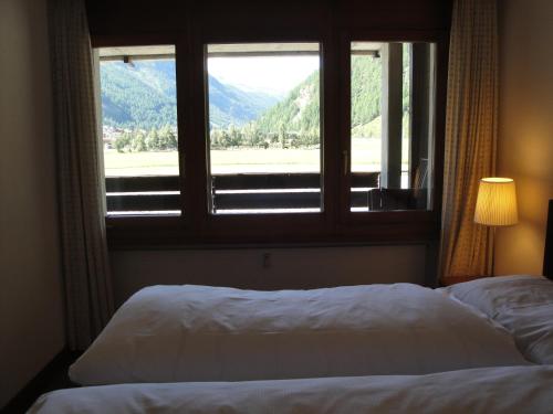 a bedroom with a bed and a window with a view at Monte Rosa D 412 in Täsch