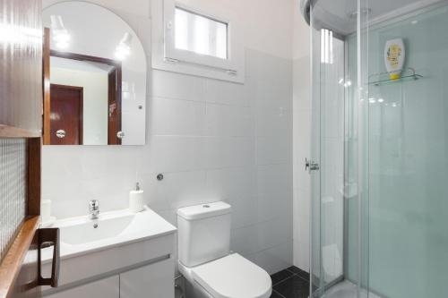 a bathroom with a toilet and a sink and a shower at Cozy Apartment Alegria Balcony in Porto
