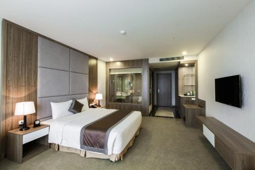 a hotel room with a bed and a television at Muong Thanh Luxury Ha Nam in Phủ Lý