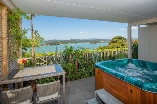 a hot tub on a balcony with a view of the water at Tarlton's Lodge in Paihia
