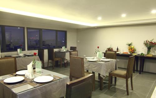 a dining room with tables and chairs and windows at Blue Pearl West Hotel in Hanoi