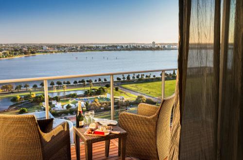 
a dining room table with a balcony overlooking the ocean at Fraser Suites Perth in Perth
