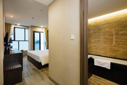 a hotel room with a bed and a bathroom at Emerald Bay Hotel & Spa Nha Trang in Nha Trang