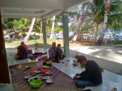 a group of people sitting on the floor eating food at Homestay Buang Sari in Gresik
