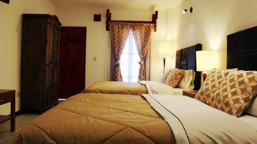 a hotel room with two beds and a window at Hotel El Cristo in Cholula