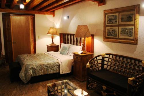 a bedroom with a bed and a chair at Hotel El Cristo in Cholula