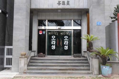 uma porta da frente de um edifício com um sinal nele em Orasung Motel em Jeju