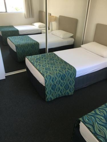 a room with three beds and two chairs at Portobello Resort Apartments in Gold Coast