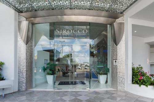 a store front with a glass door with potted plants at Mantra Sirocco in Mooloolaba