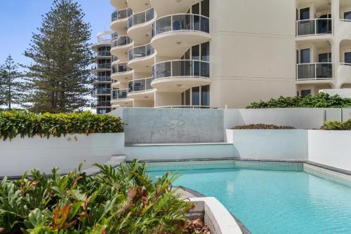 a swimming pool in front of a building at Mantra Sirocco in Mooloolaba