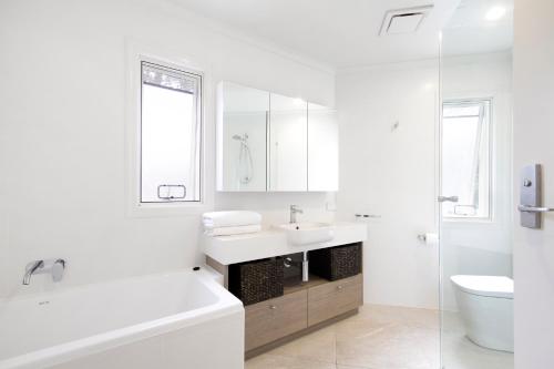 un bagno bianco con lavandino e WC di Ocean Panorama With Private Pool! a Noosa Heads
